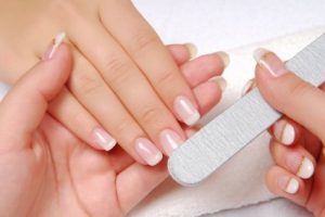 Studio nail beautician polishing female nails